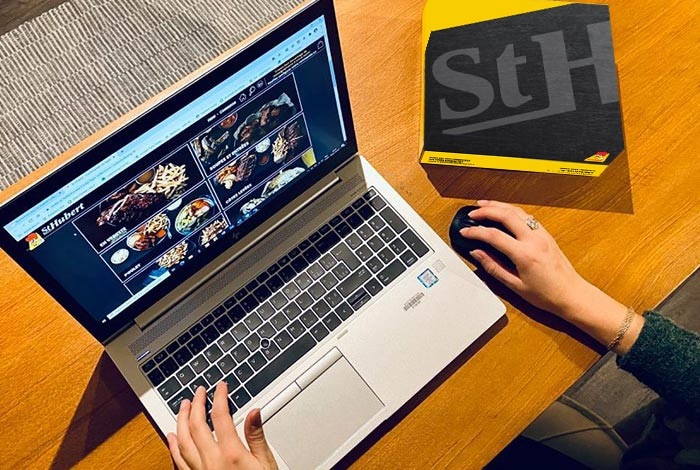 Someone ordering a meal on the St-Hubert website via a laptop