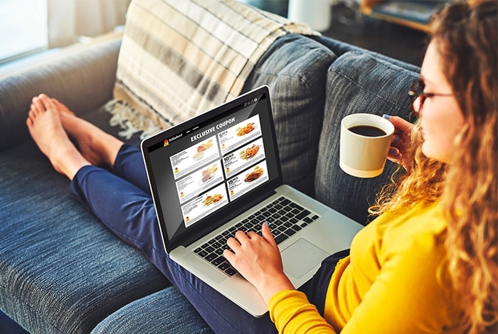 A person looking at a St-Hubert coupons and promotions booklet