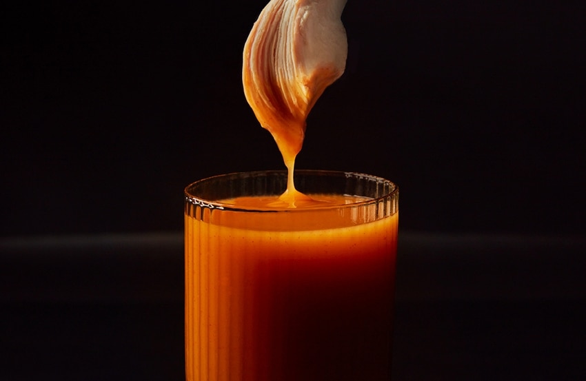 A piece of chicken dipped in St-Hubert BBQ Sauce