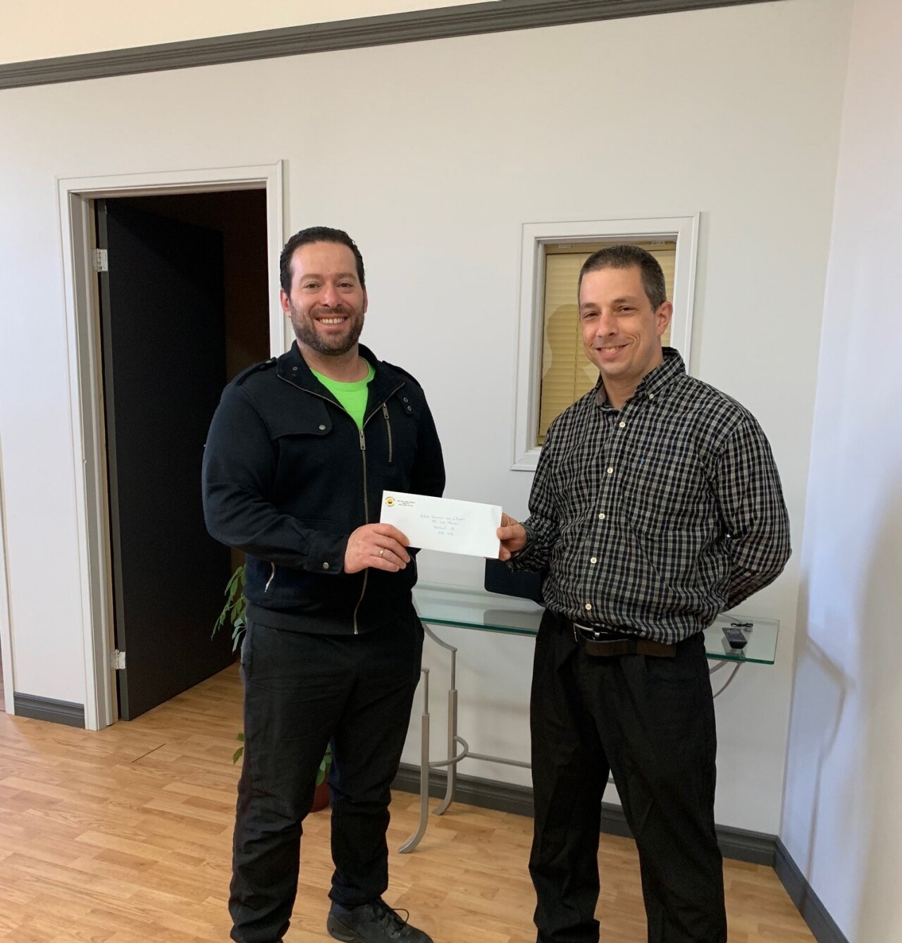 2 people holding a check for Action Secours Vie d'Espoir food counter