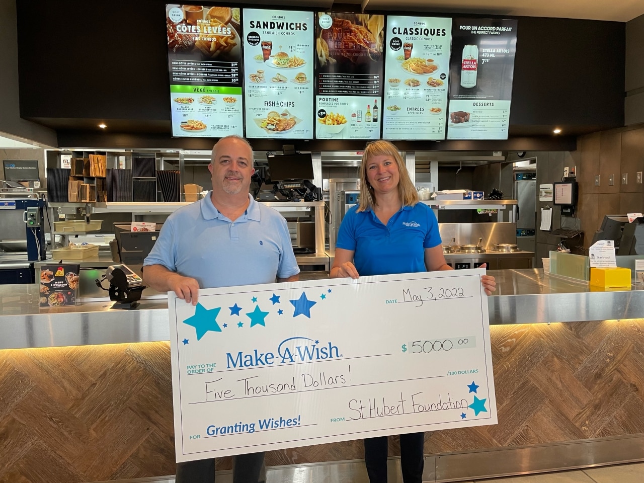 2 people holding a check for Make-A-Wish Eastern Ontario