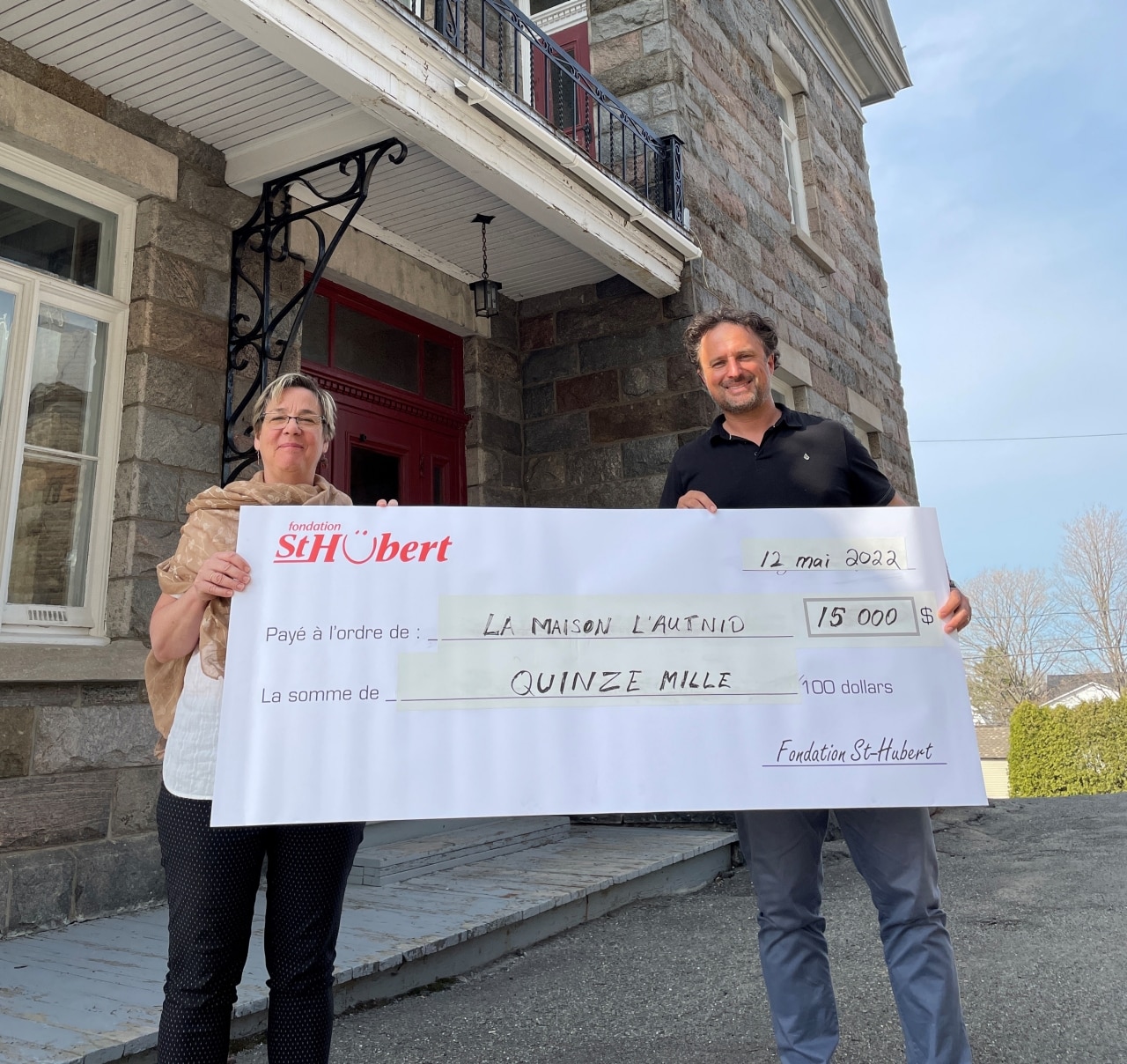 2 people holding a check for the Maison l'autnid