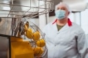 An employee in front of the machine that squeezes the lemons