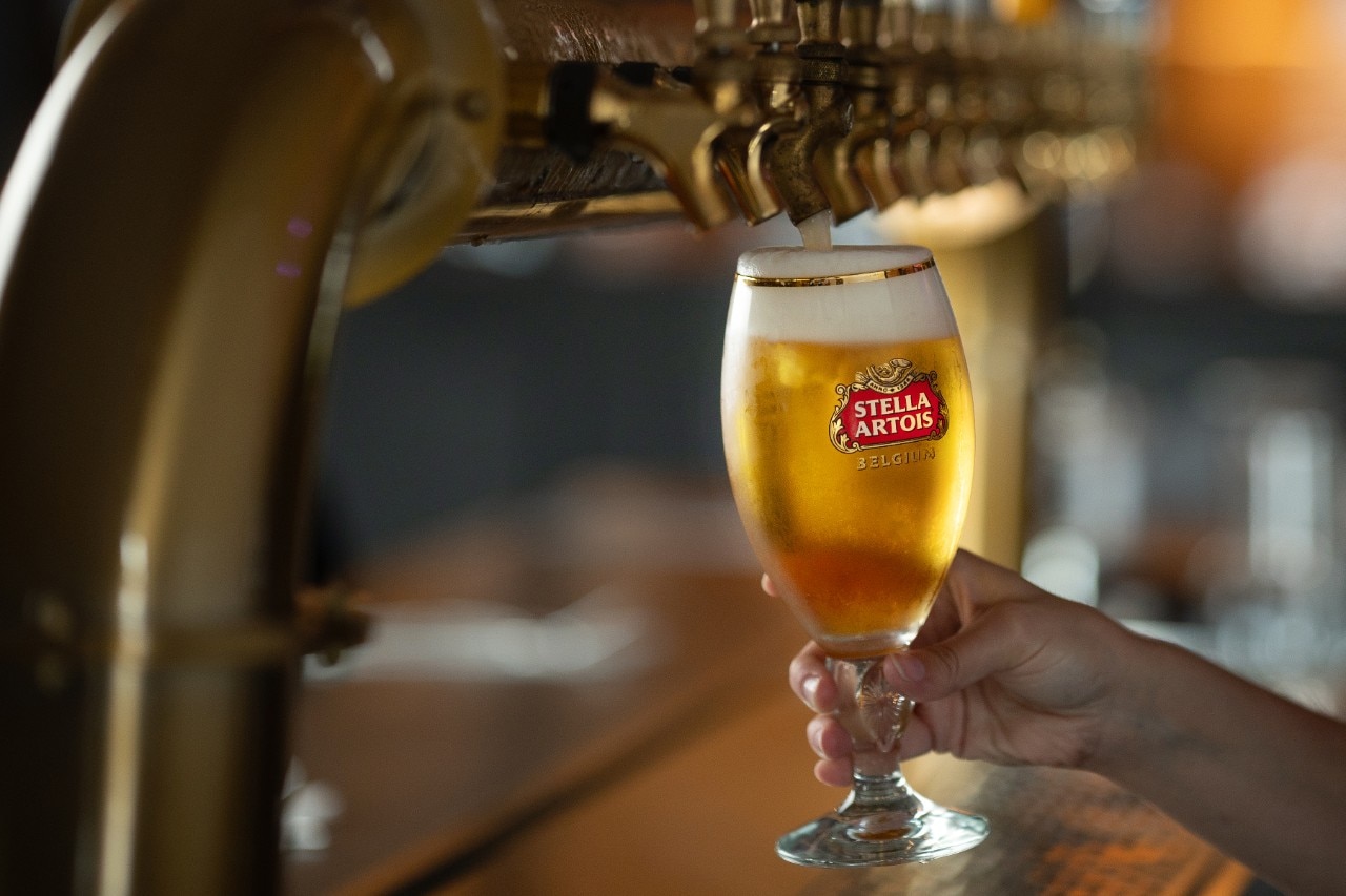 Employé en train de verser une pinte de bière de micro-brasserie locale chez St-Hubert