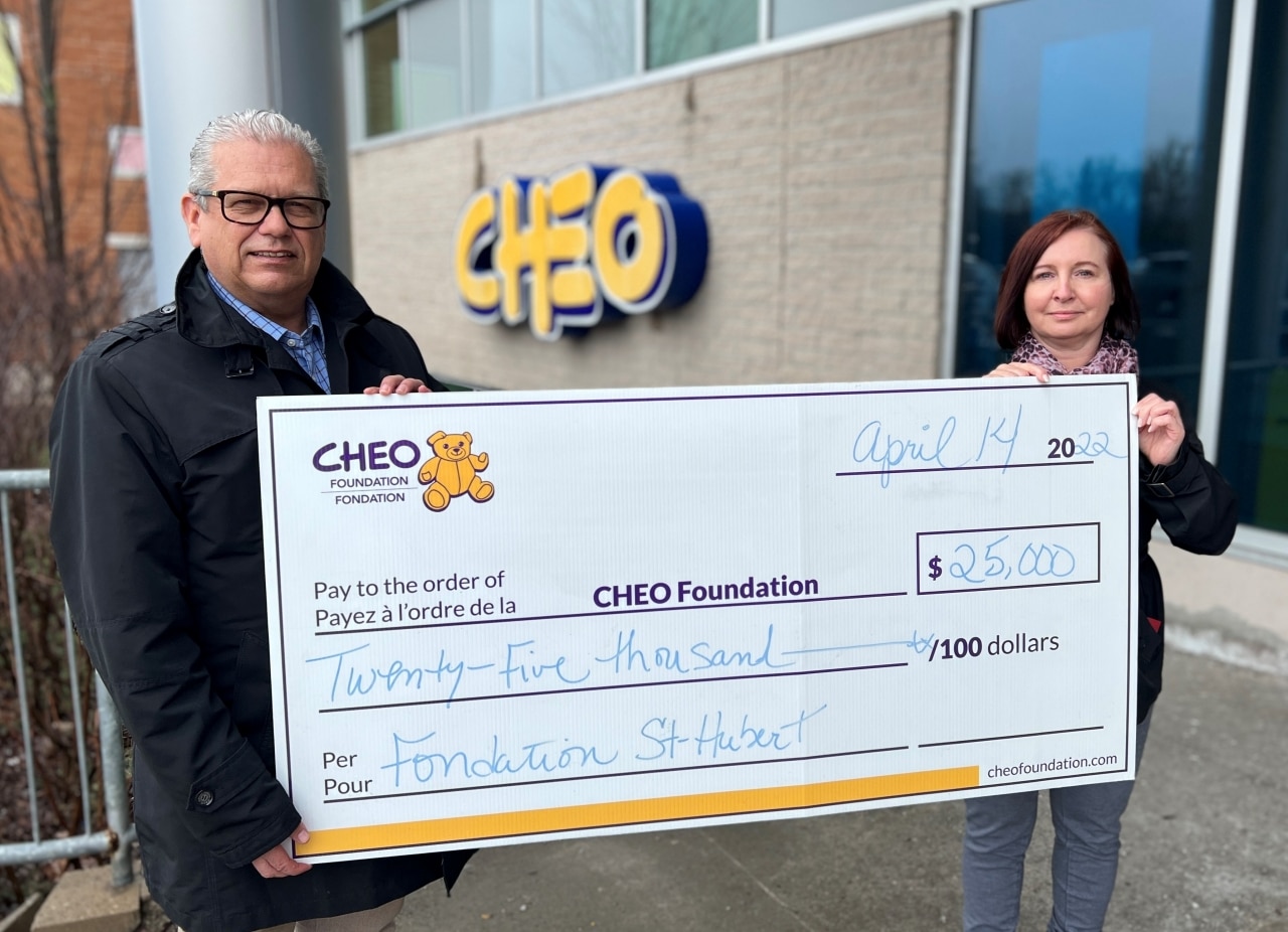 2 personnes tenant un chèque pour la Fondation CHEO