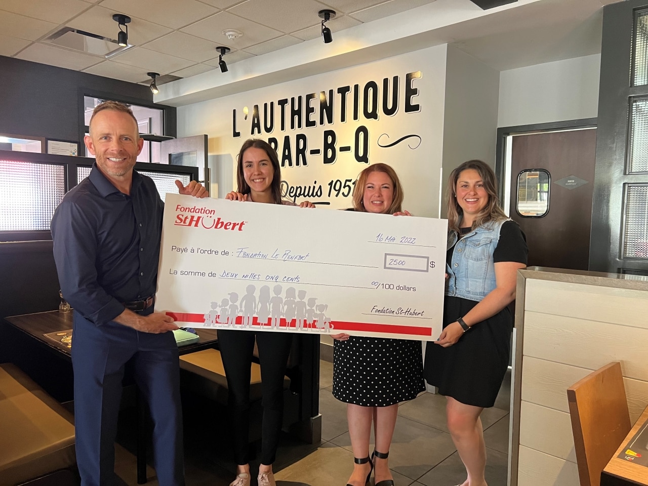 Groupe de personnes tenant un chèque pour la Fondation Le Renfort