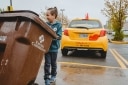 Fils d'Erasmo roulant un bac de compost dans le stationnement du St-Hubert